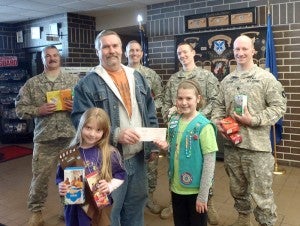 Girl Scouts Shelby and Marissa Hanson accept a donation of 1,000 boxes of Girl Scout cookies for Operation Cookie Care Package. Kevin Weitzel from Operation Vintage Pride Snowmobile presents Shelby with a check for $4,000 for the cookies that will be sent to the men and women serving in the military overseas. --Submitted
