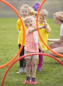 Camille Fornwald attempts to throw a bean bag through one of three Hula hoops Wednesday at Albert Lea High School during the Special Olympics Young Athletes Expo. The expo teaches basic athletic skills like throwing, catching and kicking. – Colleen Harrison/Albert Lea Tribune