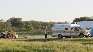 First responders hold tarps up to block the view of two vehicles involved in a fatal crash that killed two people Wednesday evening. — Sarah Stultz/Albert Lea Tribune