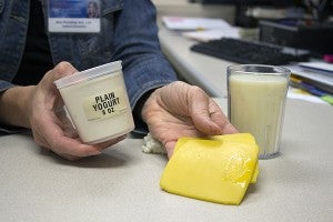 Amy Pleimling, registered dietician, shows an appopriate serving size for yogurt, cheese and milk. – Hannah Dillon/Albert Lea Tribune